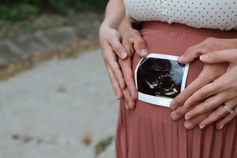 Pregnant woman holding ultrasound scan